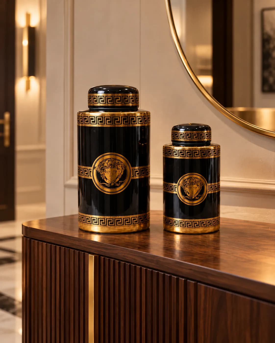 Duo de potiches noir et or sur une console en bois, sous un miroir rond, dans l’entrée d’une villa
