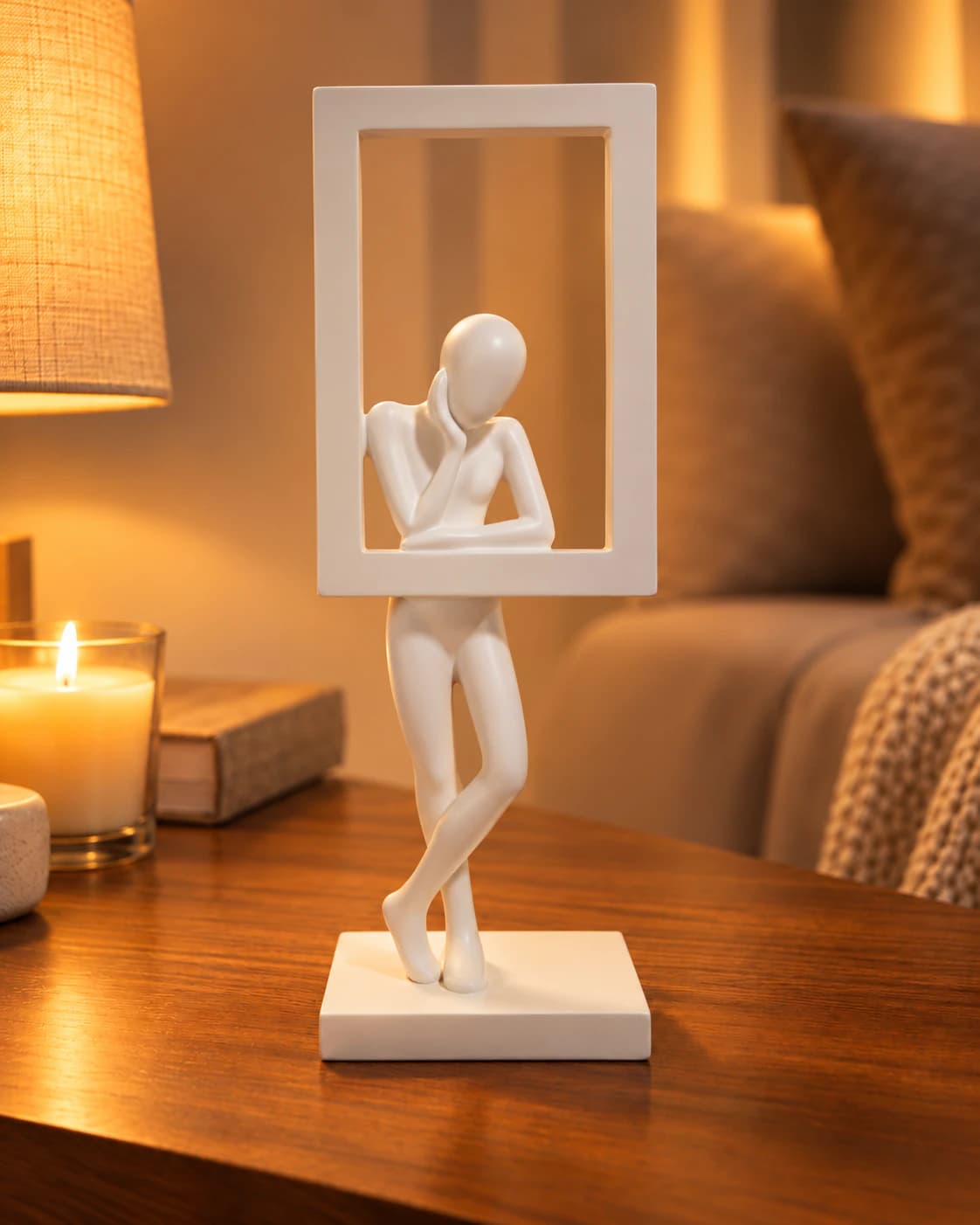 Sculpture blanche du penseur dans son cadre sur un meuble de salon, lumière chaude du soir